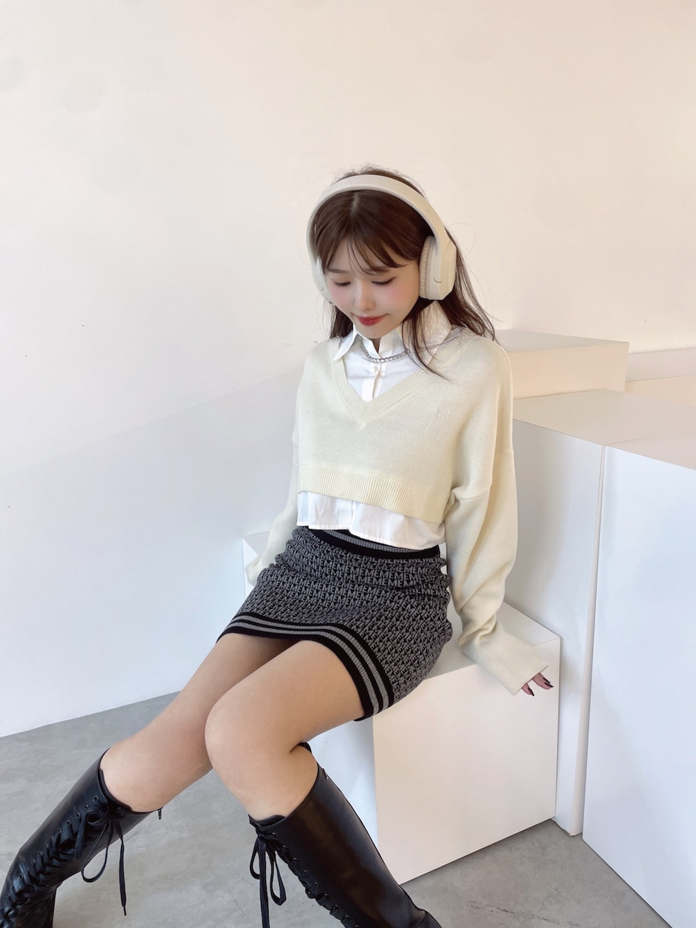 ホワイト系のシャツ/ブラウス、ブラック系のスカート、ブラック系のブーツを着用したレディースの秋コーディネートの4枚目の写真