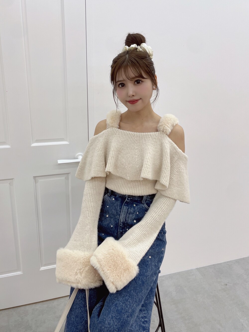 ホワイト系のニット/セーター、ブルー系のデニムパンツ、ホワイト系のパンプスを着用したレディースの秋コーディネートの4枚目の写真