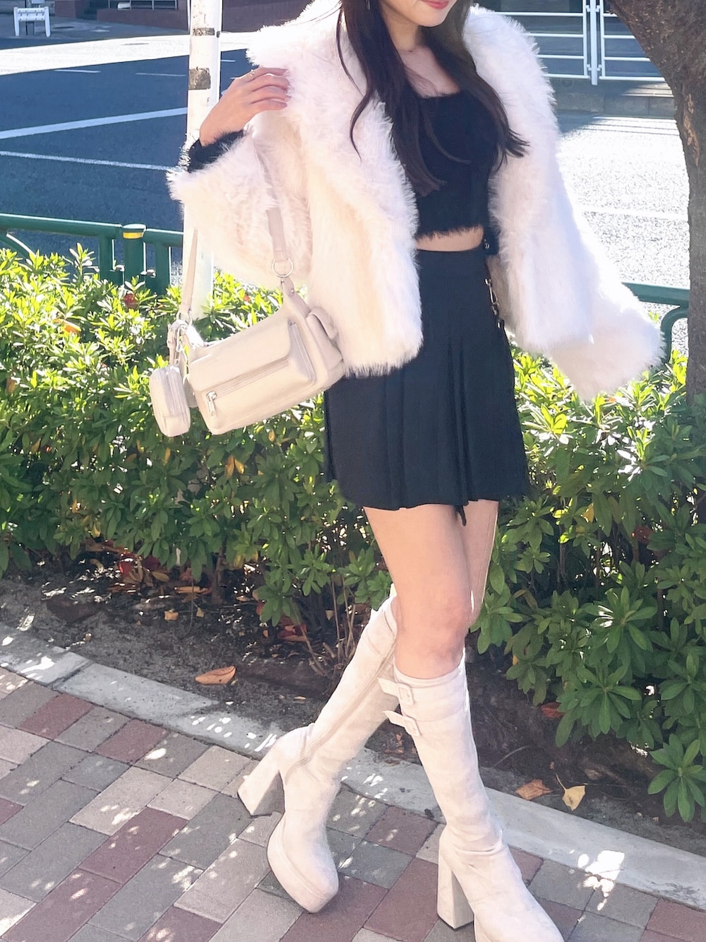 ブラック系のスカート、ホワイト系のその他アウター、ブラック系のカーディガン/ボレロを着用したレディースの冬コーディネートの2枚目の写真