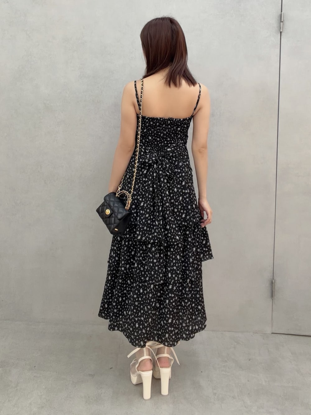 ホワイト系のサンダル、ブラック系のワンピース、ブラック系のハンドバッグを着用したレディースの冬コーディネートの5枚目の写真