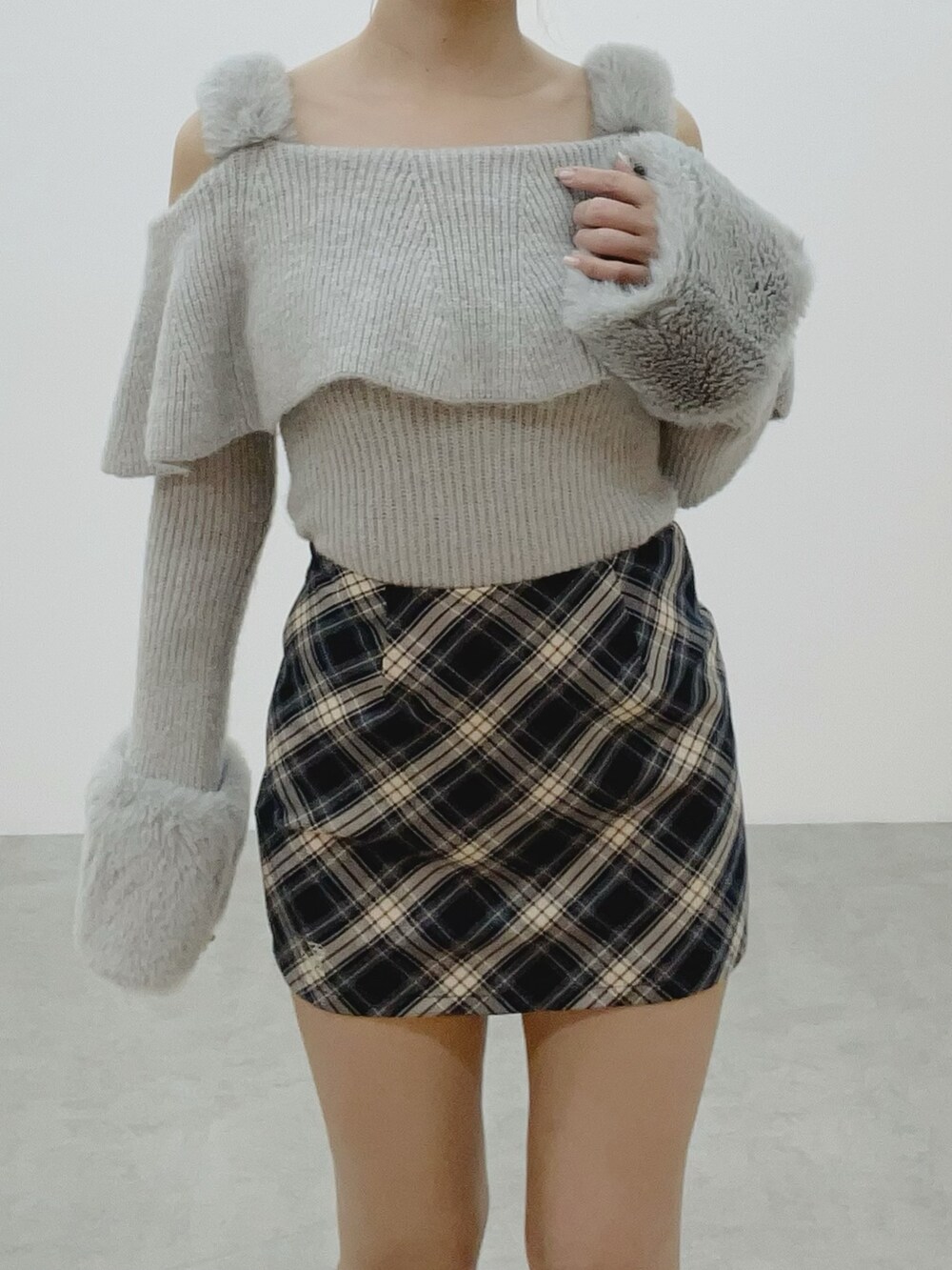 グレー系のニット/セーター、ホワイト系のブーツ、ブルー系のスカートを着用したレディースの秋コーディネートの5枚目の写真