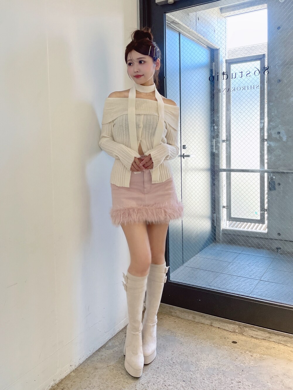 ホワイト系のニット/セーター、ホワイト系のブーツ、ピンク系のデニムスカートを着用したレディースの秋コーディネートの3枚目の写真