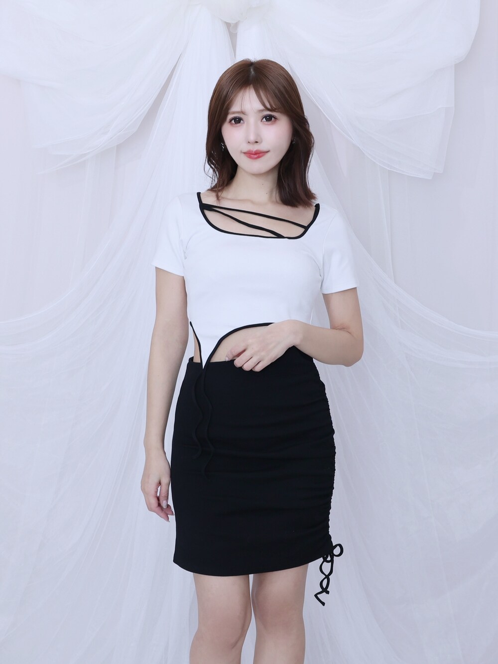 ホワイト系のワンピース、ブラック系のサンダルを着用したレディースの春コーディネートの2枚目の写真