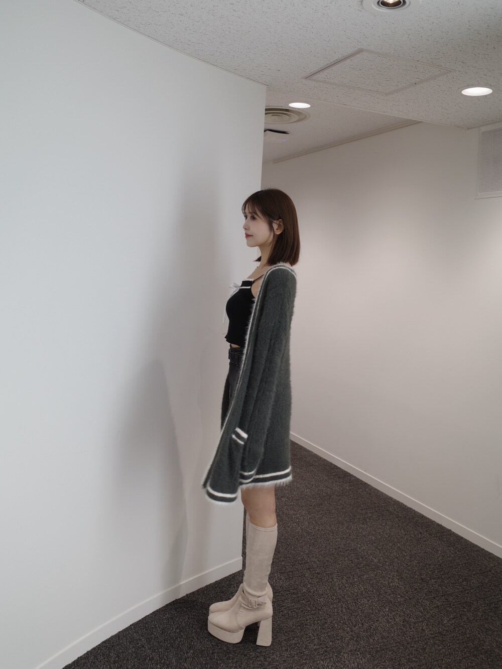 ブラック系のニット/セーター、グレー系のワンピース、ブルー系のデニムスカートを着用したレディースの秋コーディネートの6枚目の写真