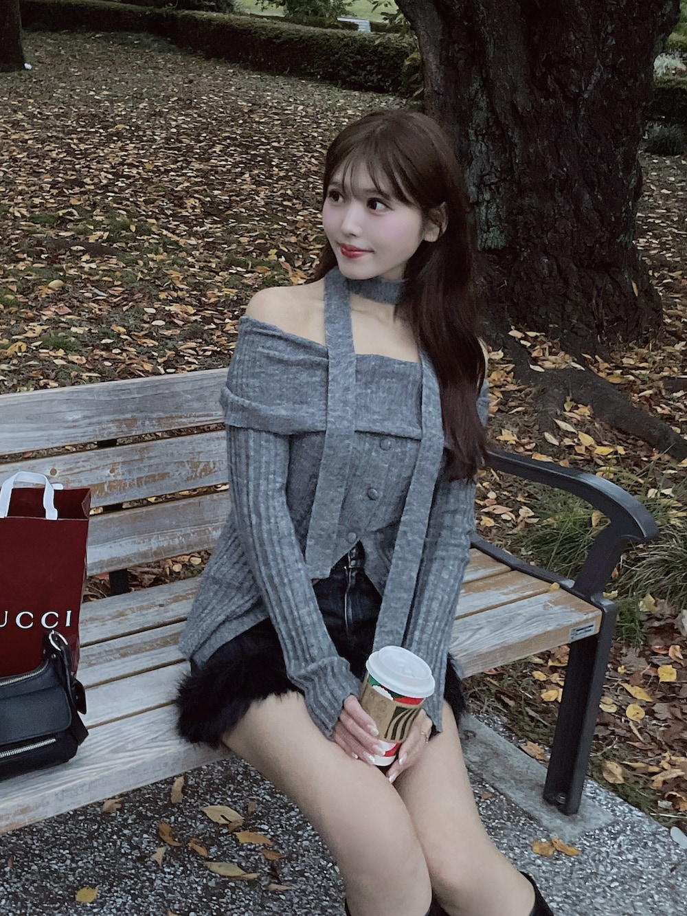 グレー系のニット/セーター、ブラック系のデニムスカートを着用したレディースの秋コーディネートの7枚目の写真