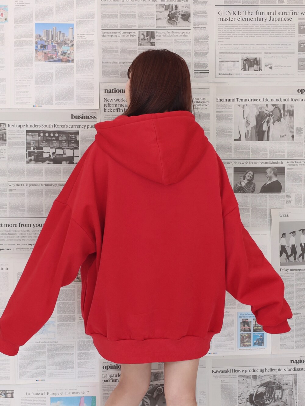 レッド系のパーカー、ブラック系のショルダーバッグ、ブラック系のブーツを着用したレディースの夏コーディネートの4枚目の写真