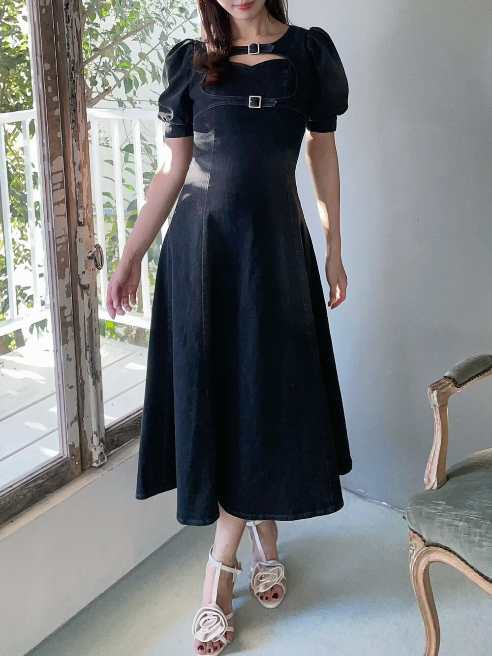 ホワイト系のハンドバッグ、ブラック系のワンピース、ホワイト系のサンダルを着用したレディースの春コーディネートの3枚目の写真