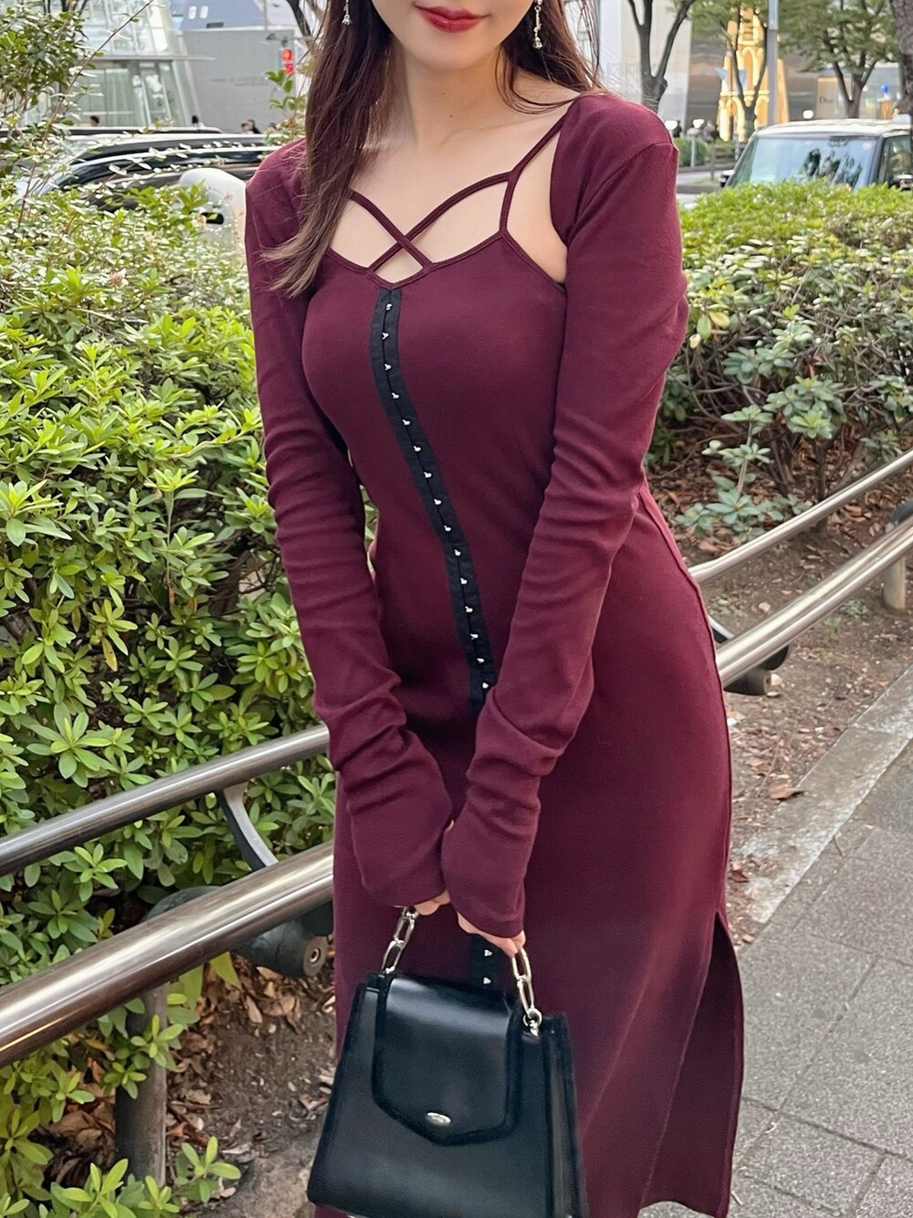 ブラック系のショルダーバッグ、レッド系のワンピース、ブラック系のパンプスを着用したレディースの秋コーディネートの4枚目の写真