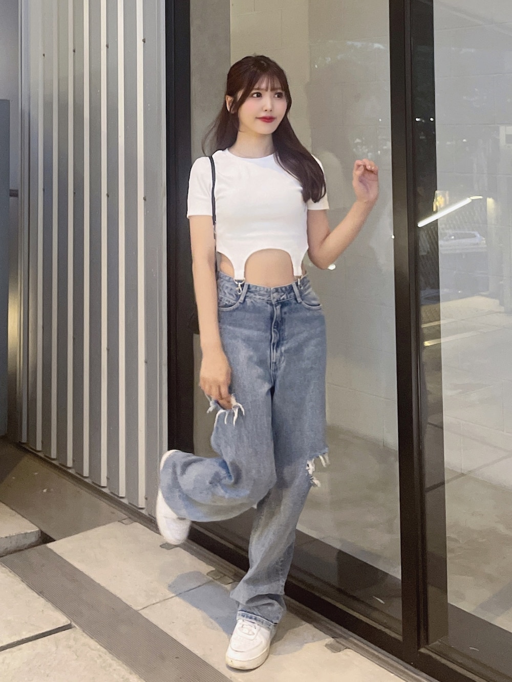 ブルー系のデニムパンツ、ホワイト系のTシャツ/カットソー、ブラック系のショルダーバッグを着用したレディースの春コーディネートの2枚目の写真