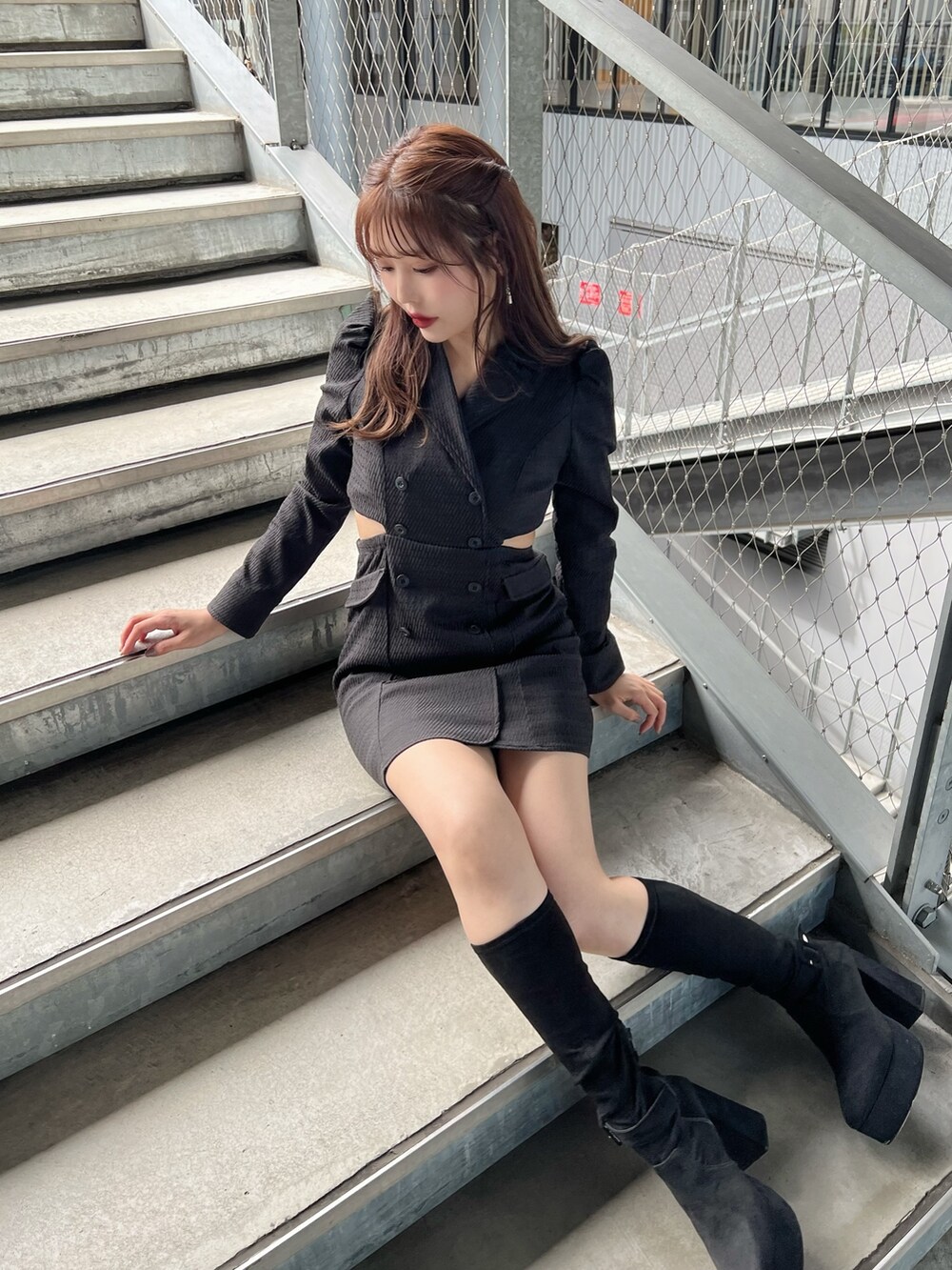 ブラック系のワンピース、ブラック系のブーツを着用したレディースの秋コーディネートの2枚目の写真