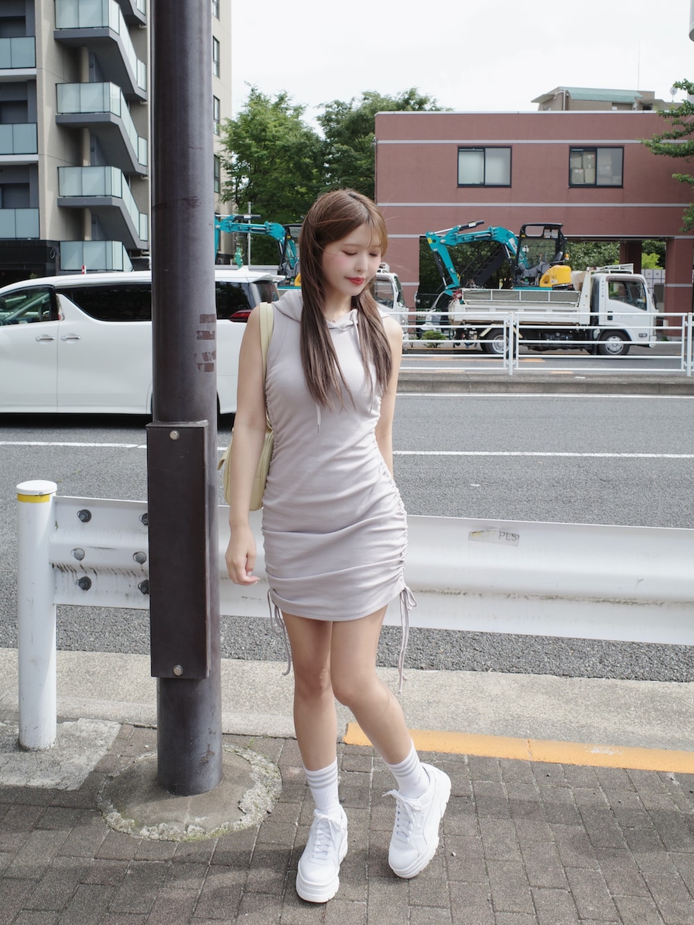 グレー系のワンピース、ホワイト系のスニーカー、イエロー系のボストンバッグを着用したレディースの夏コーディネートの2枚目の写真