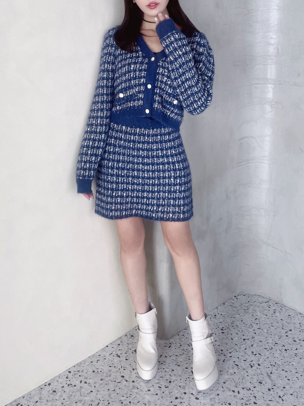 ブルー系のカーディガン/ボレロ、ブルー系のスカート、ホワイト系のブーツを着用したレディースの秋コーディネートの2枚目の写真