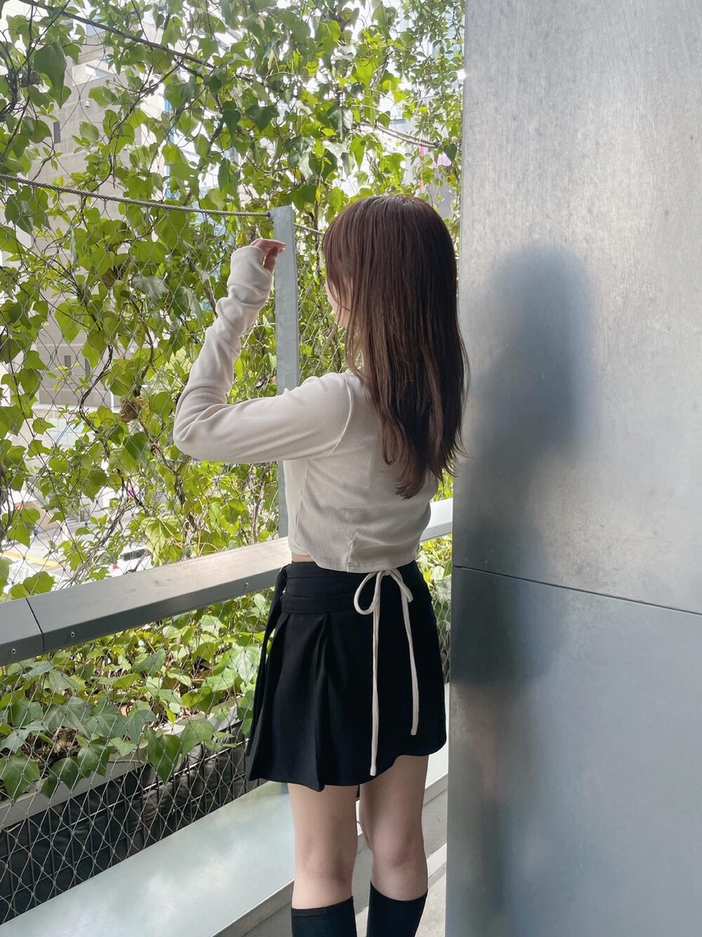 ホワイト系のTシャツ/カットソー、ブラック系のショルダーバッグ、ブラック系のスカートを着用したレディースの秋コーディネートの4枚目の写真