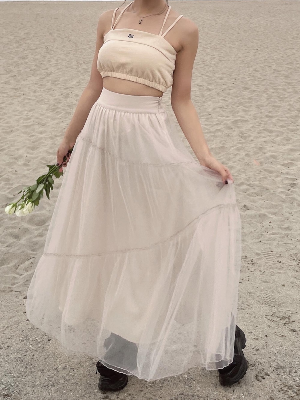 イエロー系のキャミソール、ベージュ系のスカートを着用したレディースの春コーディネートの8枚目の写真