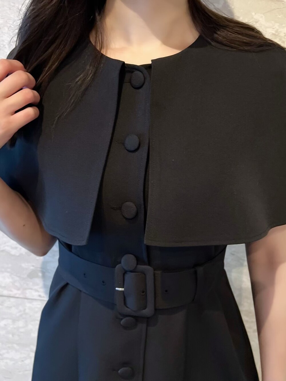 ブラック系のワンピース、ブラック系のサンダル、ホワイト系のショルダーバッグを着用したレディースの夏コーディネートの3枚目の写真