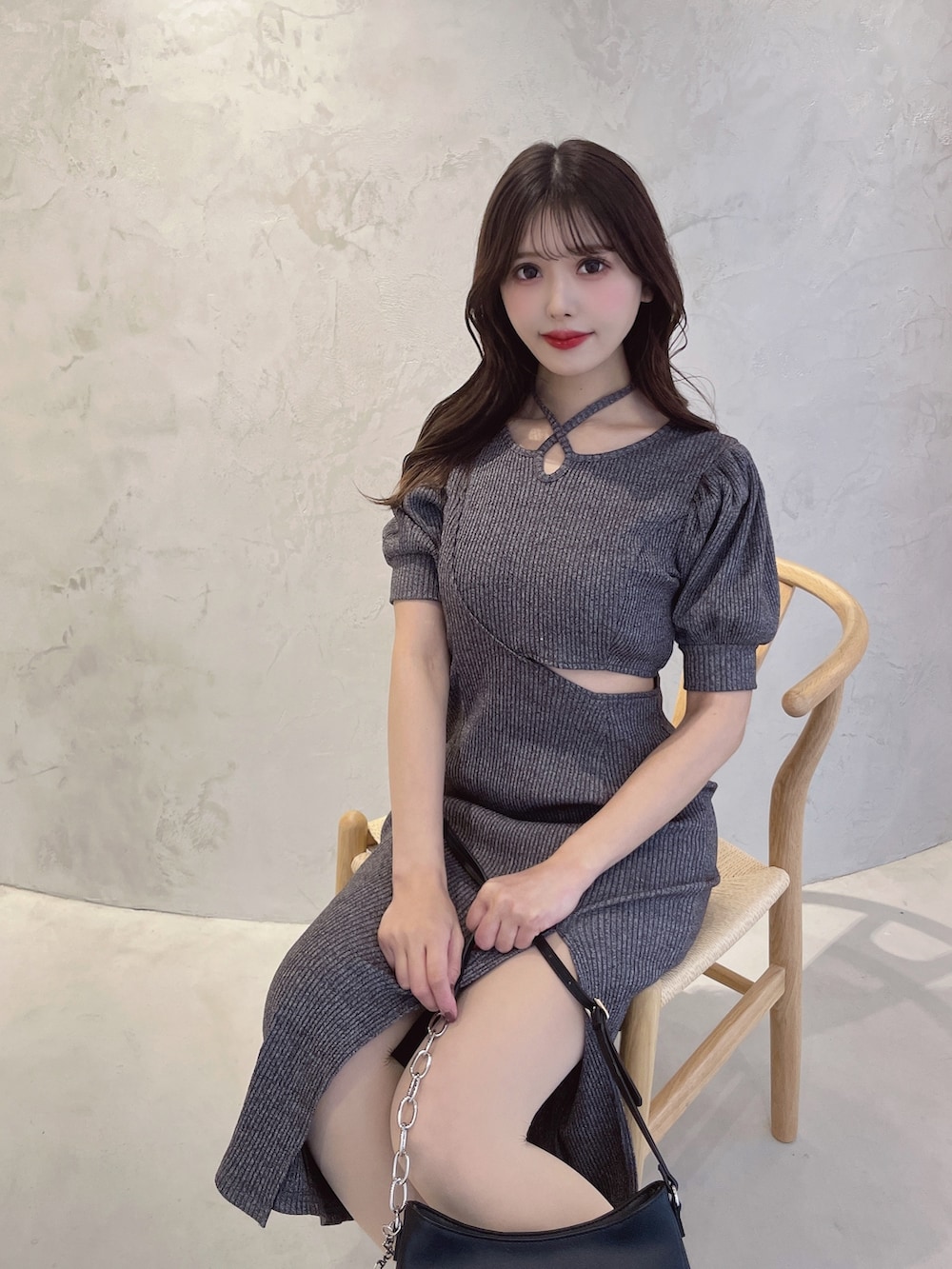 グレー系のワンピース、ブラック系のショルダーバッグ、ブルー系のサンダルを着用したレディースの春コーディネートの3枚目の写真