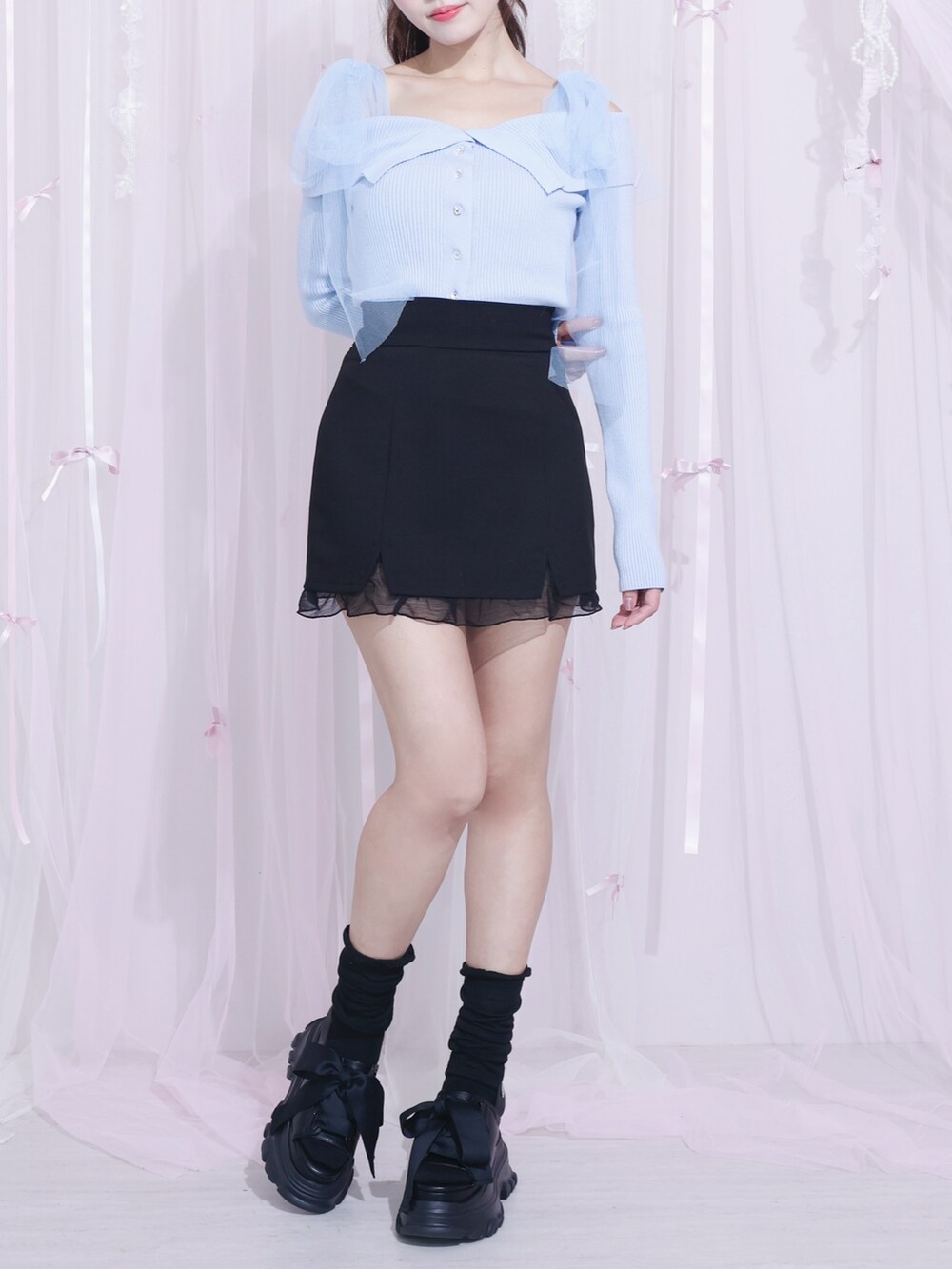 ブラック系のスカート、ブルー系のニット/セーターを着用したレディースの冬コーディネートの4枚目の写真