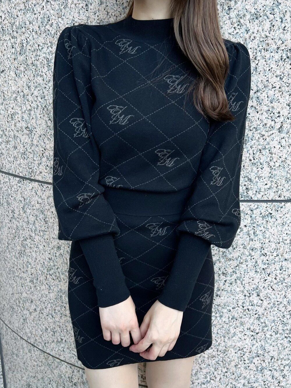 ブラック系のニット/セーター、ホワイト系のブーツ、ブラック系のスカートを着用したレディースの秋コーディネートの5枚目の写真