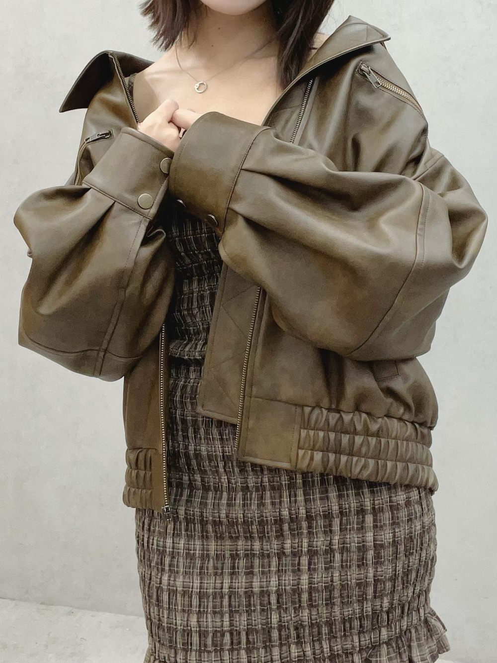 ブラウン系のワンピース、ブラウン系のブルゾン、ホワイト系のブーツを着用したレディースの秋コーディネートの6枚目の写真