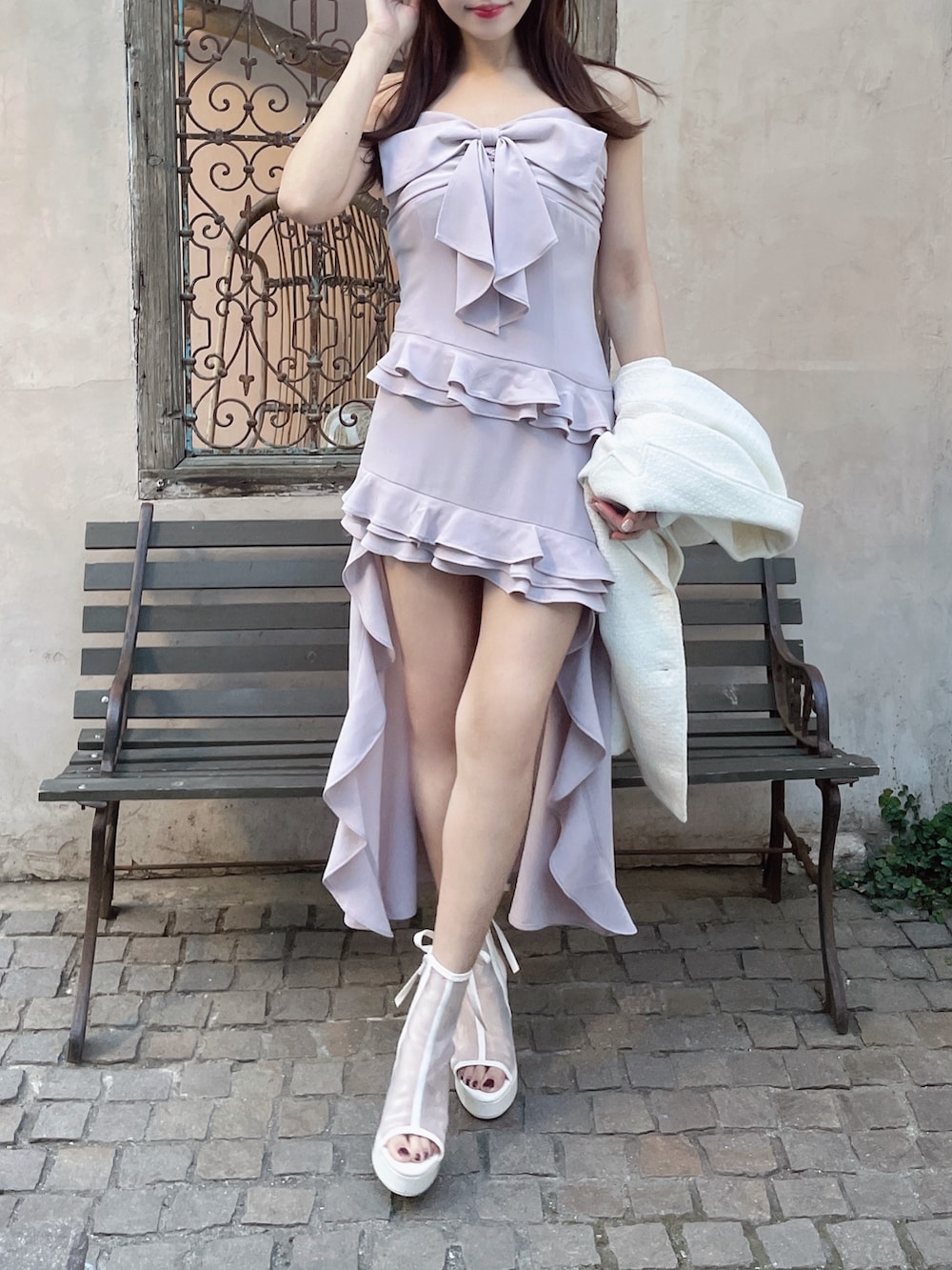 ホワイト系のテーラードジャケット、ホワイト系のサンダル、ピンク系のワンピースを着用したレディースの夏コーディネートの4枚目の写真