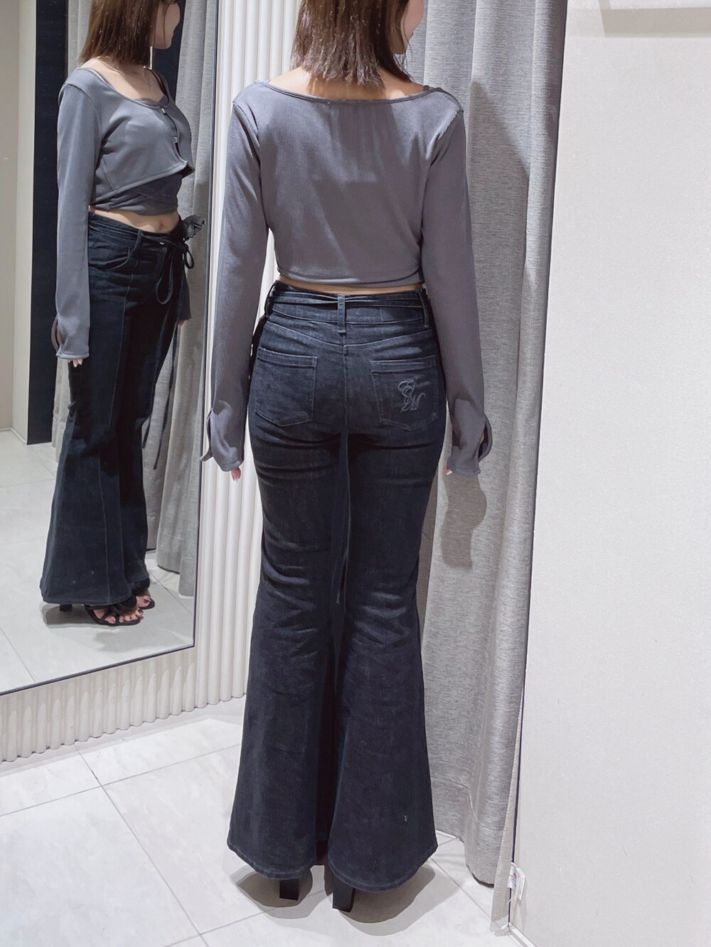 グレー系のTシャツ/カットソー、ブラック系のデニムパンツ、ブラック系のサンダルを着用したレディースの春コーディネートの6枚目の写真