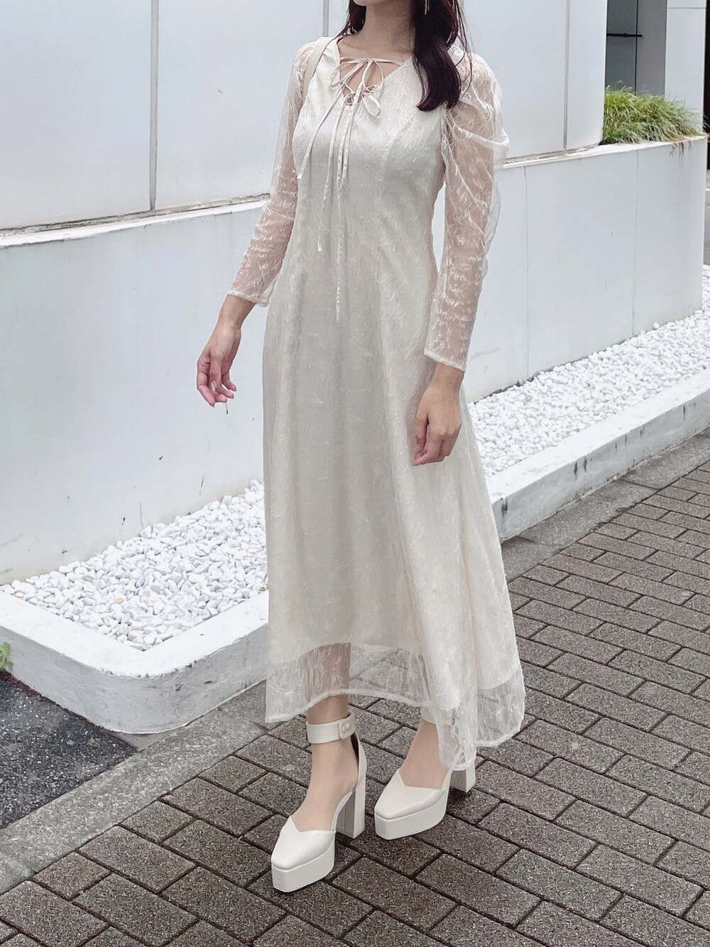 ホワイト系のパンプス、ホワイト系のハンドバッグ、ホワイト系のワンピースを着用したレディースの夏コーディネートの4枚目の写真