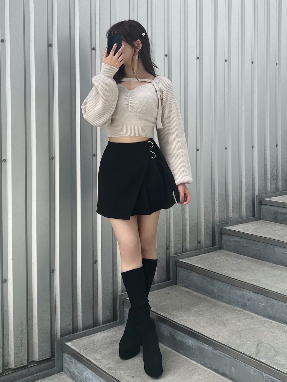 ブラック系のブーツ、ブラック系のスカート、グレー系のニット/セーターを着用したレディースの秋コーディネートの4枚目の写真