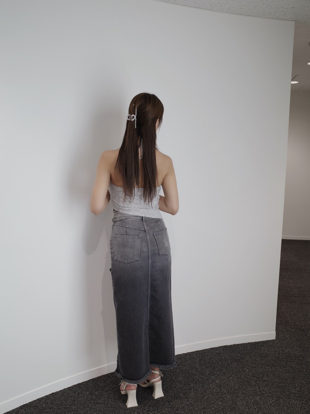 ブラック系のデニムスカート、ホワイト系のサンダル、グレー系のキャミソールを着用したレディースの夏コーディネートの8枚目の写真