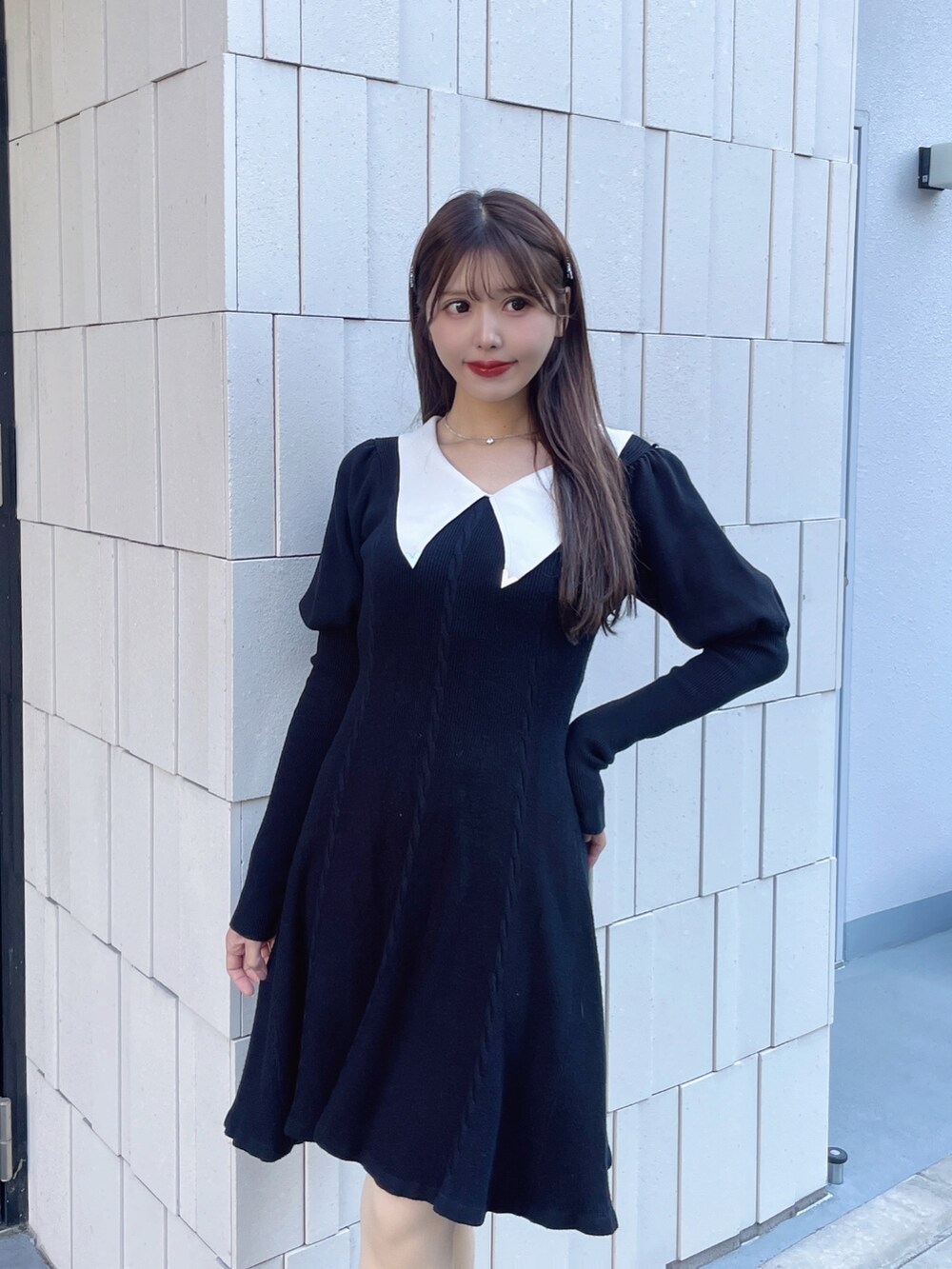 ブラック系のワンピース、レッド系のパンプス、シルバー系のネックレスを着用したレディースの冬コーディネートの4枚目の写真