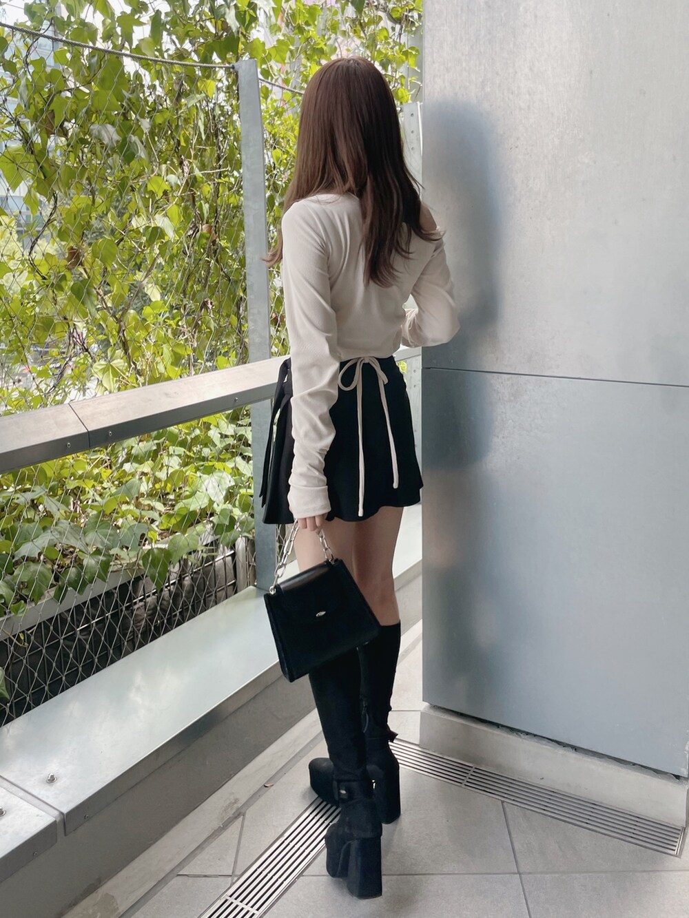 ホワイト系のTシャツ/カットソー、ブラック系のショルダーバッグ、ブラック系のスカートを着用したレディースの秋コーディネートの6枚目の写真