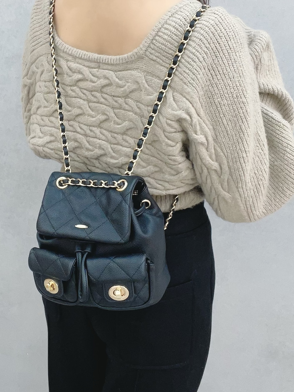 ベージュ系のニット/セーター、ブラック系のその他パンツ、ブラック系のブーツを着用したレディースの冬コーディネートの6枚目の写真