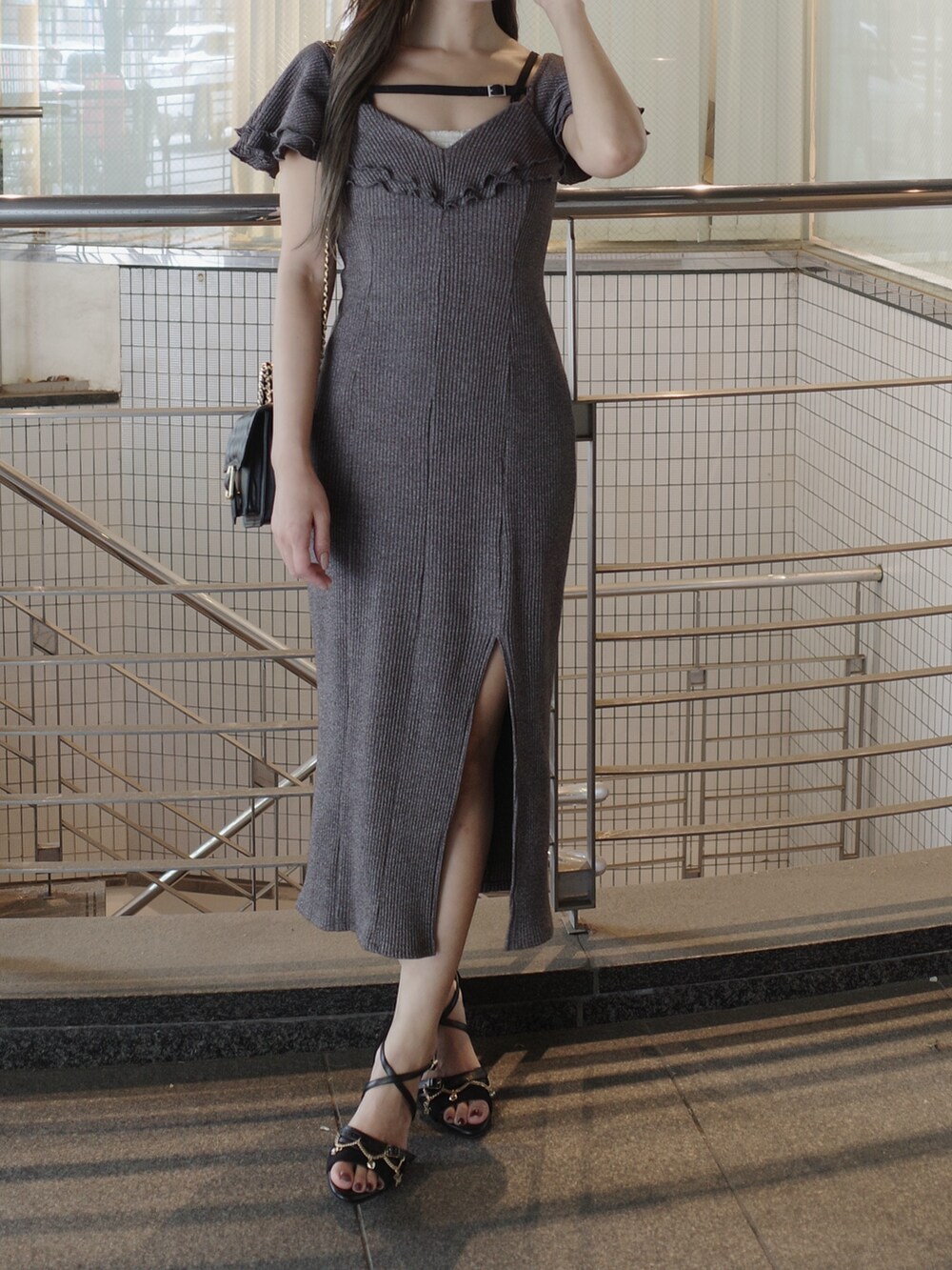 グレー系のワンピース、ブラック系のサンダル、ブラック系のショルダーバッグを着用したレディースの夏コーディネートの2枚目の写真