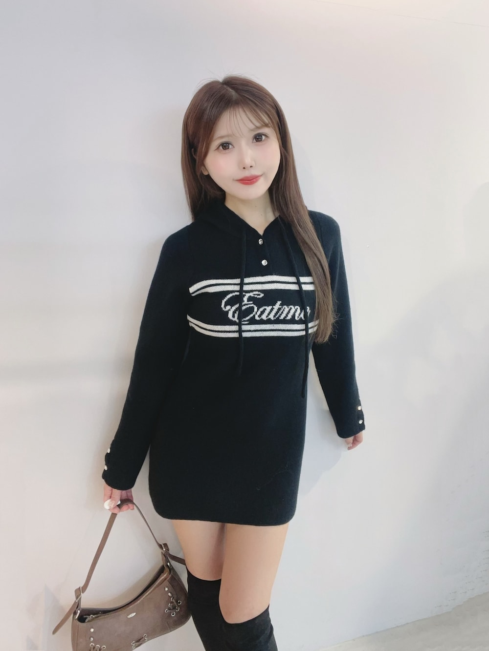 ブラック系のワンピース、ブラック系のブーツ、ブラウン系のショルダーバッグを着用したレディースの秋コーディネートの5枚目の写真