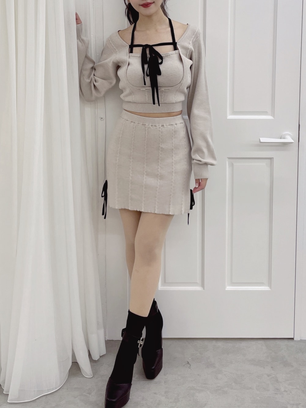 グレー系のニット/セーター、グレー系のスカートを着用したレディースの夏コーディネートの4枚目の写真