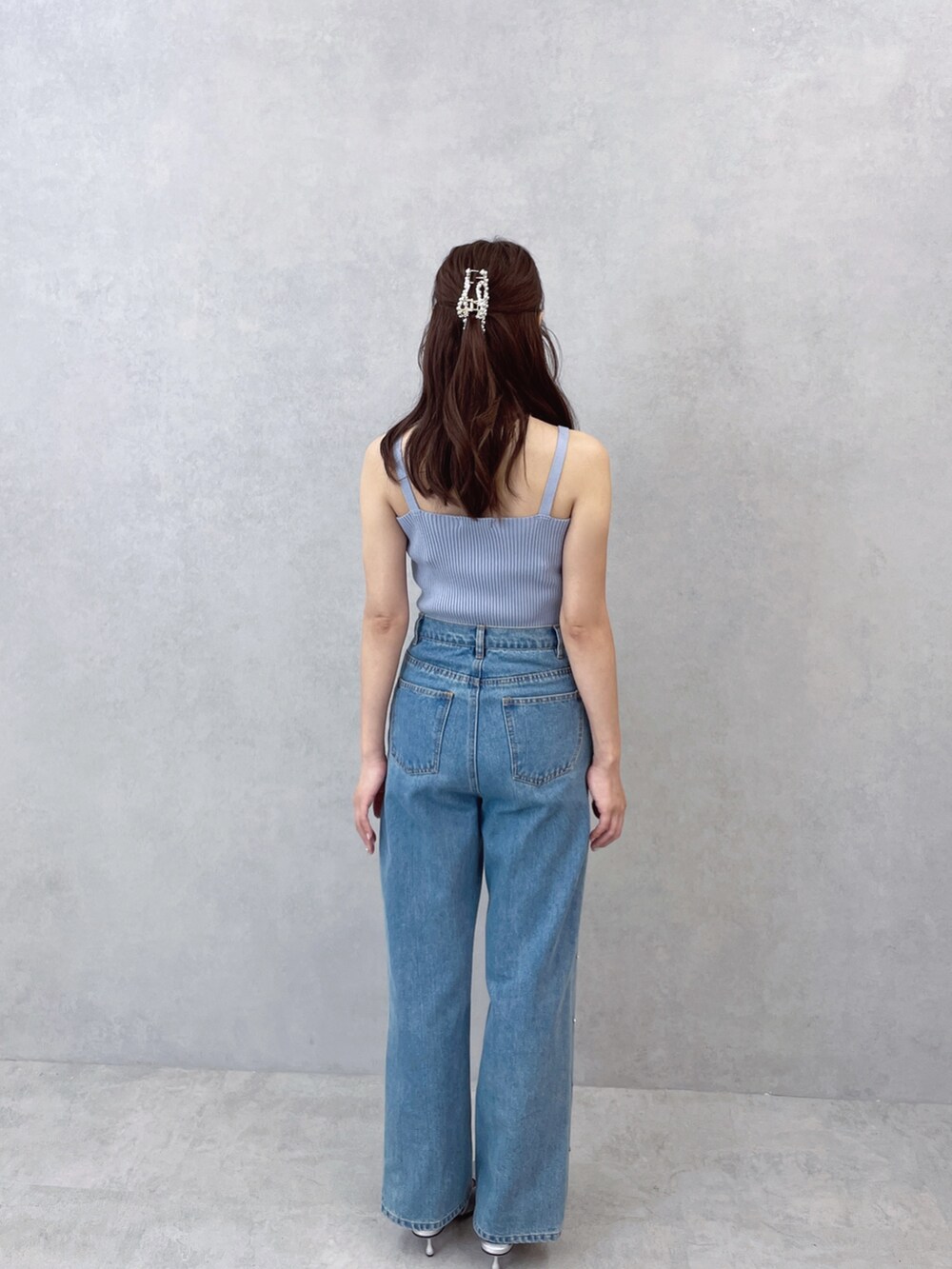 ブルー系のキャミソール、ブルー系のデニムパンツ、シルバー系のネックレスを着用したレディースの夏コーディネートの6枚目の写真