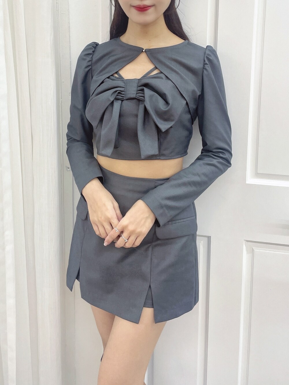 グレー系のワンピース、ブラック系のブーツを着用したレディースの秋コーディネートの2枚目の写真