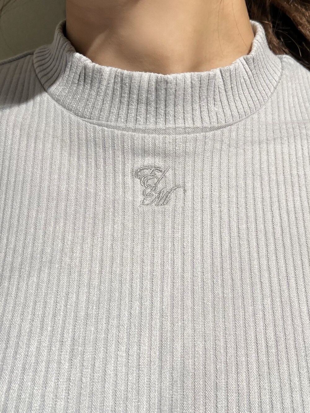 グレー系のニット/セーター、ブラック系のスカート、ブラック系のパンプスを着用したレディースの春コーディネートの4枚目の写真