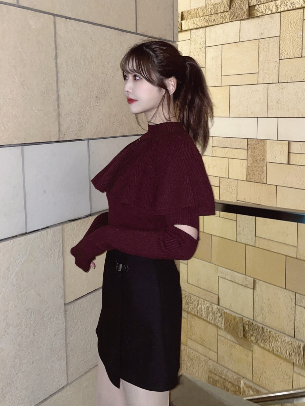 レッド系のニット/セーター、ブラック系のスカートを着用したレディースの冬コーディネートの5枚目の写真