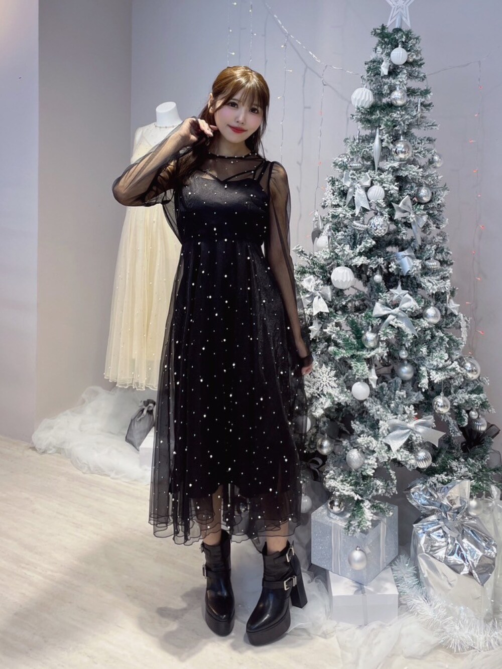 ブラック系のワンピース、ブラック系のブーツを着用したレディースの秋コーディネートの2枚目の写真