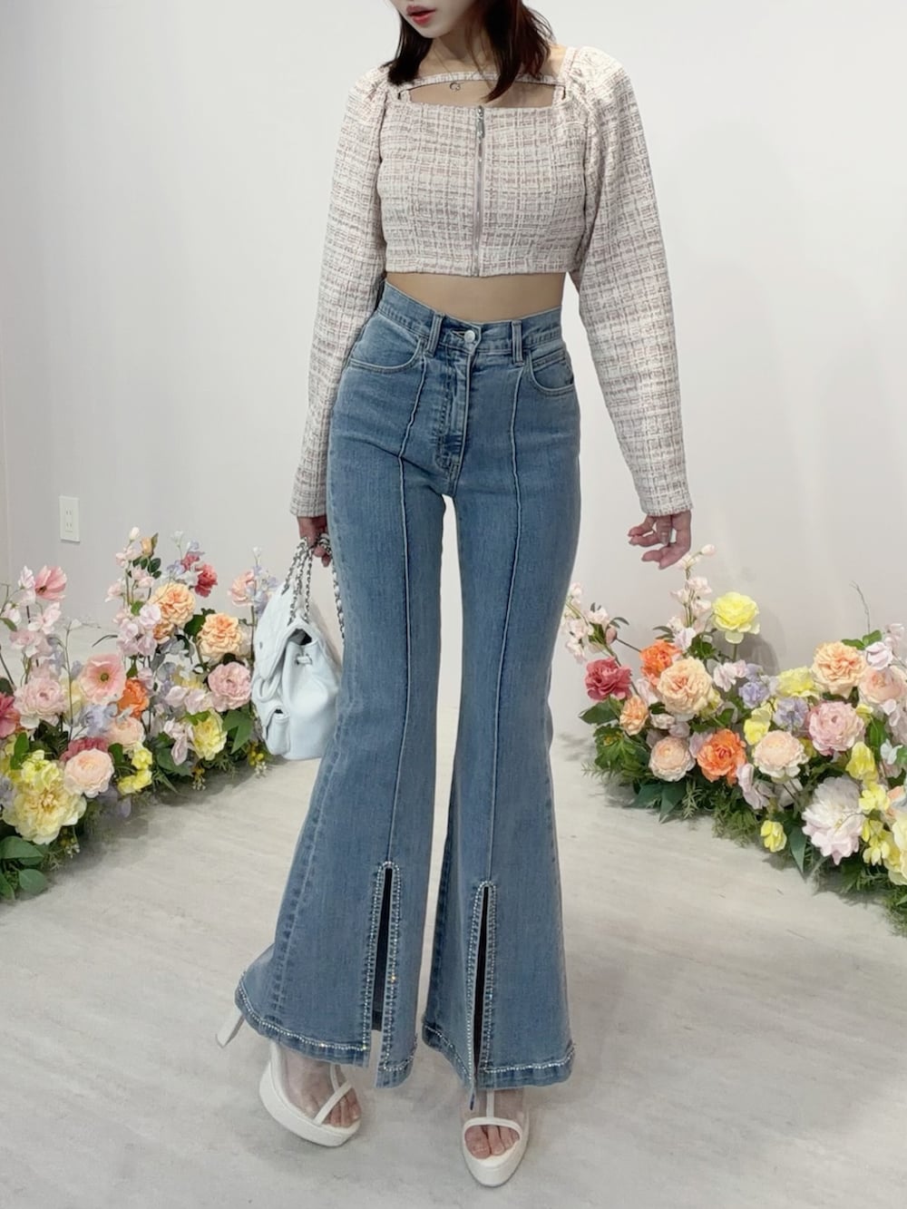 ブルー系のデニムパンツ、ホワイト系のバックパック/リュック、ホワイト系のサンダルを着用したレディースの冬コーディネートの2枚目の写真