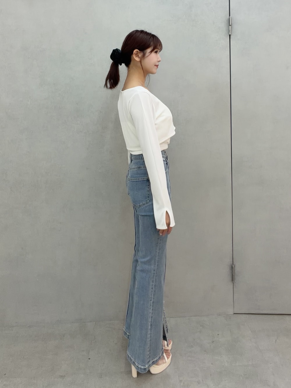 ブルー系のデニムパンツ、ホワイト系のTシャツ/カットソー、ホワイト系のサンダルを着用したレディースの冬コーディネートの4枚目の写真