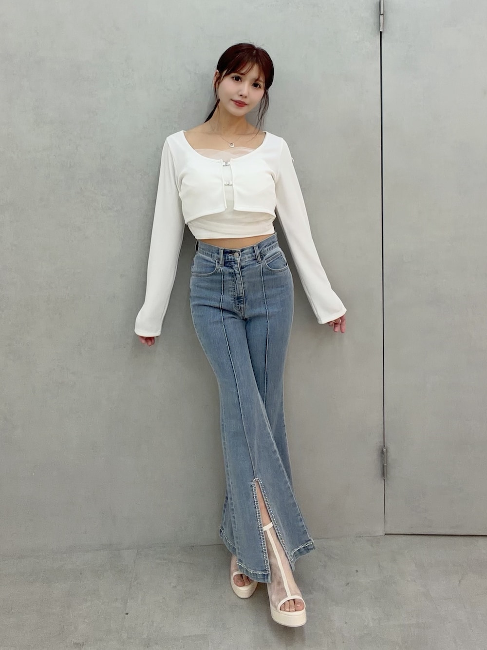 ブルー系のデニムパンツ、ホワイト系のTシャツ/カットソー、ホワイト系のサンダルを着用したレディースの冬コーディネートの2枚目の写真