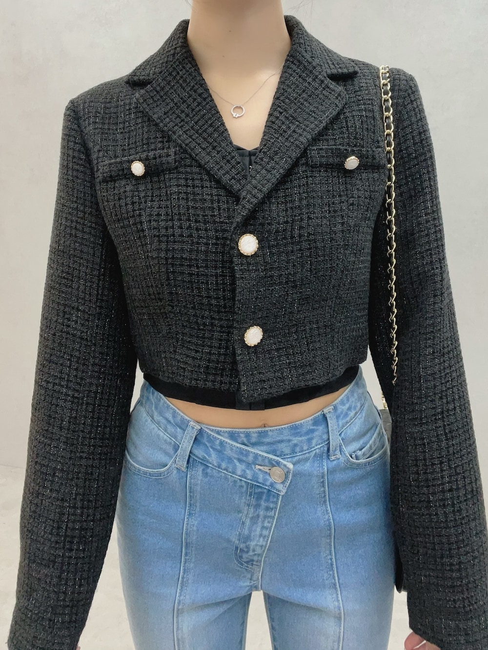 ブルー系のデニムパンツ、ブラック系のサンダル、ブラック系のテーラードジャケットを着用したレディースの秋コーディネートの8枚目の写真