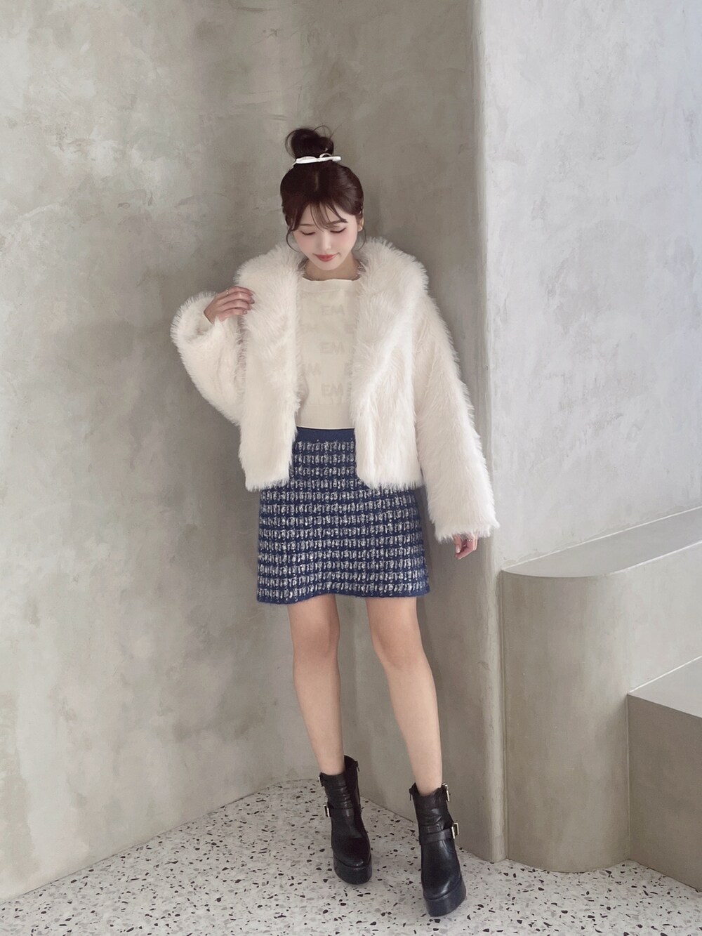 ホワイト系のその他アウター、ブルー系のスカート、ブラック系のブーツを着用したレディースの秋コーディネートの2枚目の写真