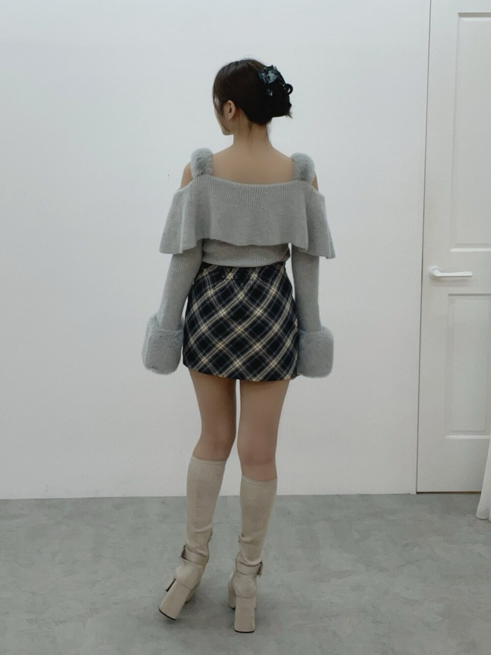 グレー系のニット/セーター、ホワイト系のブーツ、ブルー系のスカートを着用したレディースの秋コーディネートの4枚目の写真