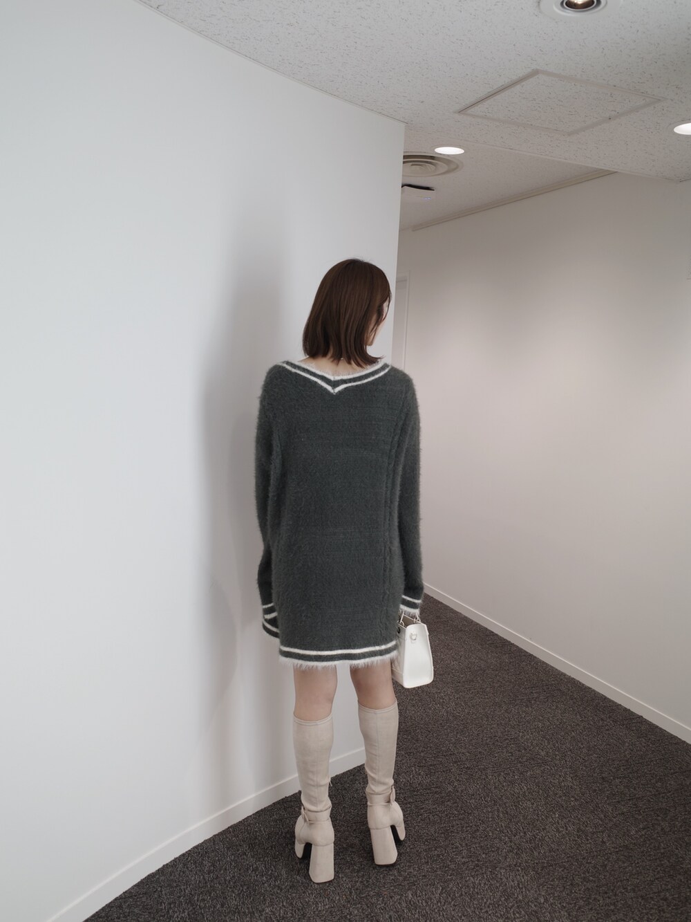ブラック系のニット/セーター、グレー系のワンピース、ブルー系のデニムスカートを着用したレディースの秋コーディネートの7枚目の写真