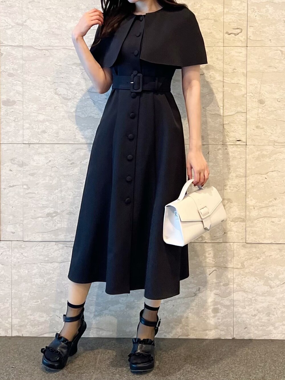 ブラック系のワンピース、ブラック系のサンダル、ホワイト系のショルダーバッグを着用したレディースの夏コーディネートの5枚目の写真