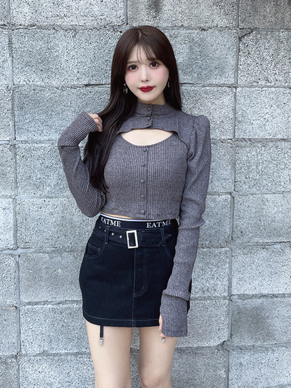 グレー系のTシャツ/カットソー、ブラック系のスカート、ブラック系のブーツを着用したレディースの秋コーディネートの3枚目の写真