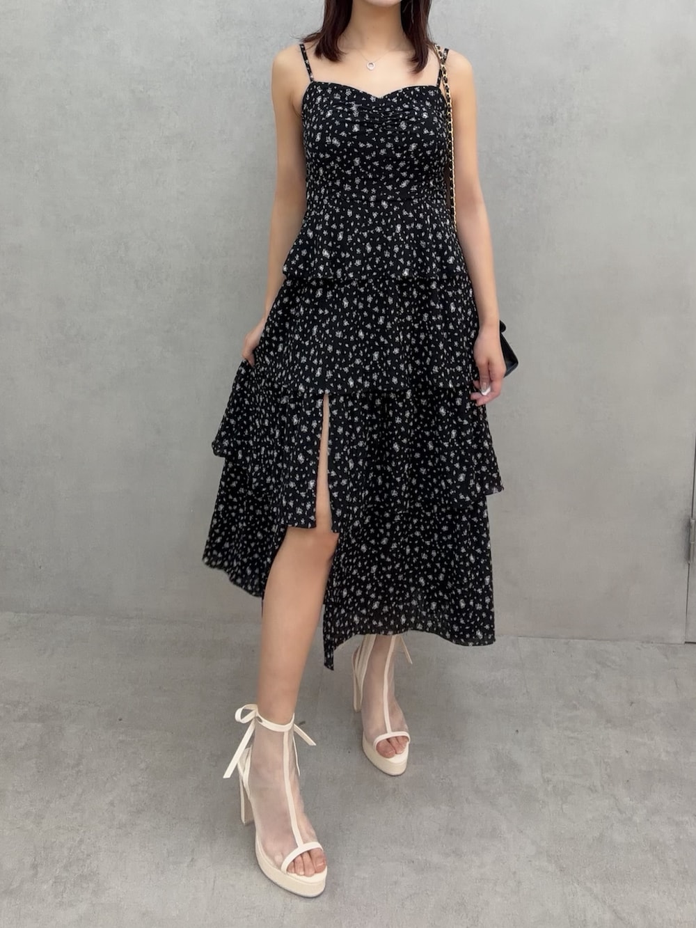 ホワイト系のサンダル、ブラック系のワンピース、ブラック系のハンドバッグを着用したレディースの冬コーディネートの3枚目の写真