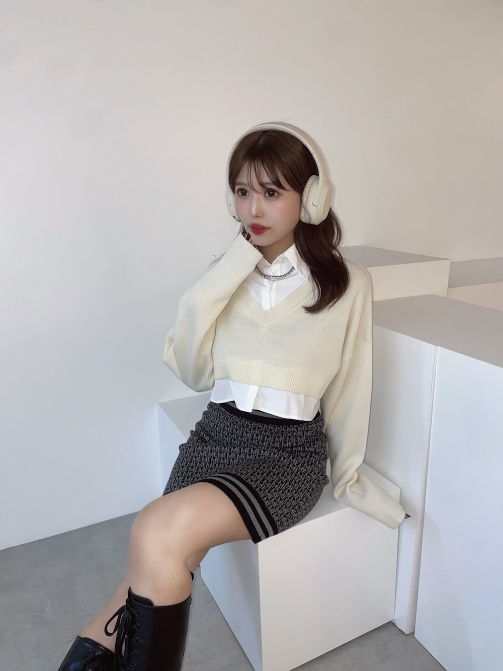 ホワイト系のシャツ/ブラウス、ブラック系のスカート、ブラック系のブーツを着用したレディースの秋コーディネートの2枚目の写真